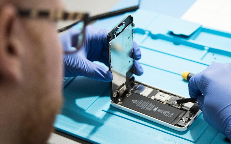 echnicien intervenant sur un iPhone en atelier &agrave; Saint-Tropez